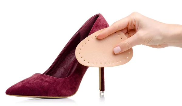 Női piros bőr magas sarkú cipő talpbetét a kezében — Stock Fotó