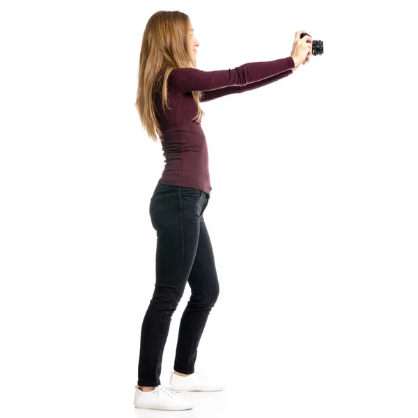Vrouw in zwarte jeans en shirt met camera in de hand — Stockfoto