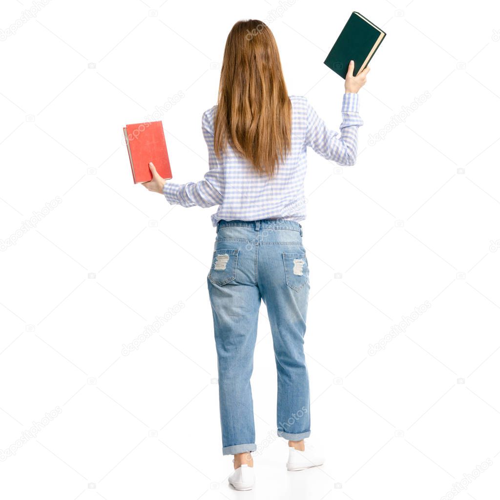 Woman in blue jeans and shirt with books in hands