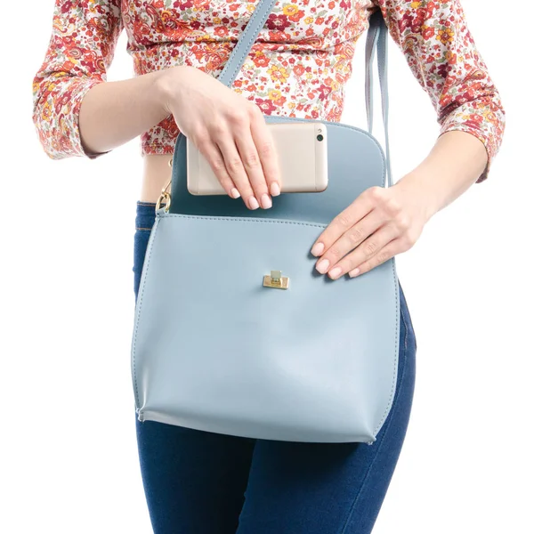 Kadın mavi kot pantolon ve gömlek smartphone mavi çanta makroda koydu.