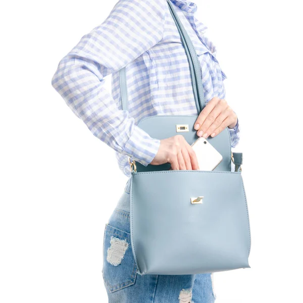 Kadın mavi tişört ve kot smartphone mavi çanta makroda koydu.