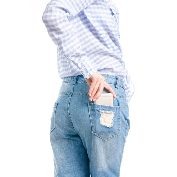 Woman in jeans and blue shirt put smartphone in pocket macro — Stock Photo, Image