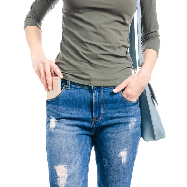 Woman in jeans and green shirt bag put smartphone pocket in hand macro — Stock Photo, Image