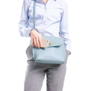 Kadın gri pantolon ve el makro mavi gömlek mavi çanta akıllı telefon