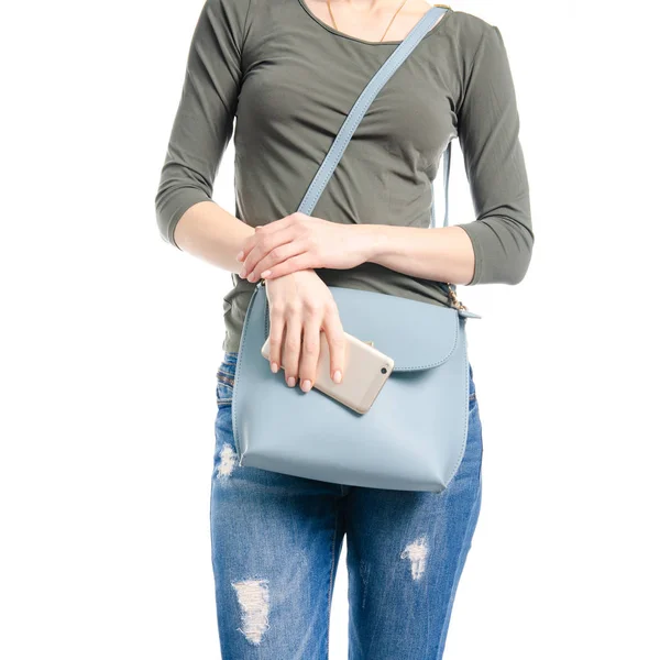 Woman in jeans and green shirt bag smartphone in hand macro — Stock Photo, Image