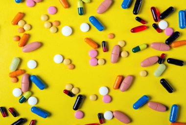 Renkli hapları sarı arka plan yukarıdan eczane kavramı üzerinde tıbbi