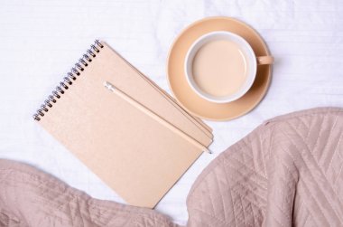 Fincan kahve Not defteri kalem bir beyaz kahverengi yatakta