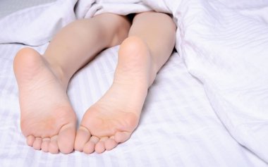 Beyaz yatakta kadın bacakları güzellik