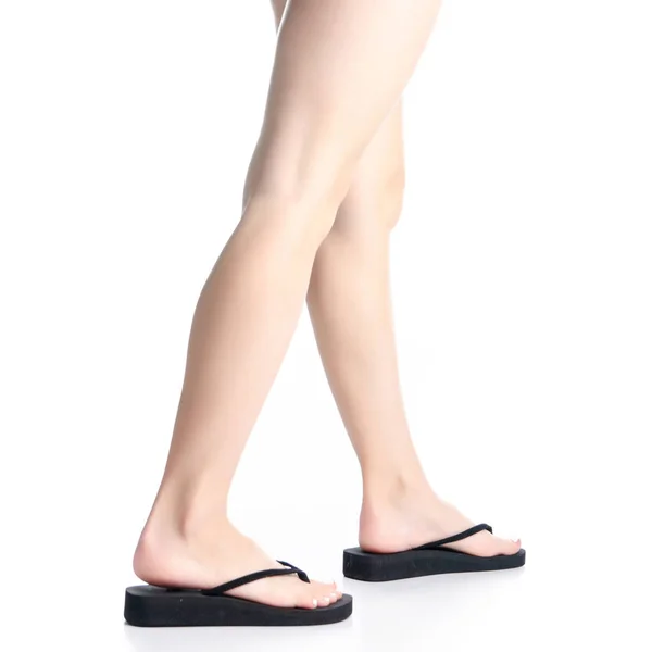 De benen van de vrouw in zwarte flip flops gaat — Stockfoto