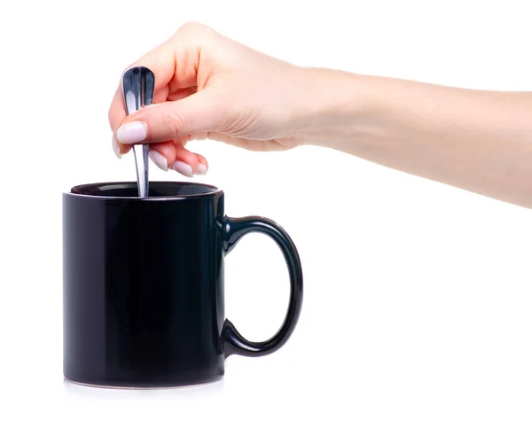 Cangkir hitam dengan sendok teh di tangan — Stok Foto