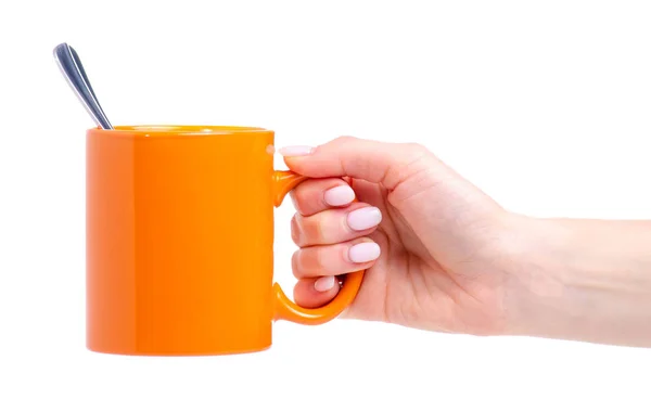 Taza de naranja taza con cuchara de té en la mano —  Fotos de Stock