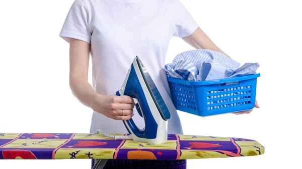 Un panier à linge à la main femme et fer à repasser sur planche à repasser — Photo