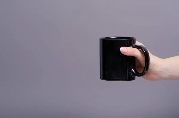 Caneca de xícara preta na mão — Fotografia de Stock