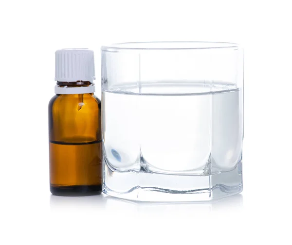 El frasco de medicamento gotea en un vaso de agua — Foto de Stock