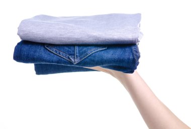 katlanmış kot pantolon ve elinde gri t-shirt