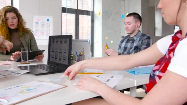 Творческая команда, работающая над пользовательским интерфейсом в офисе — стоковое видео