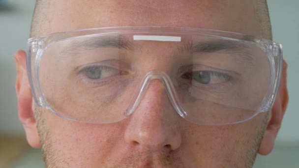 Close up van mannelijke gezicht in veiligheidsbril of bril — Stockvideo