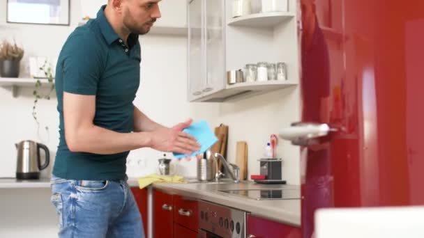 Mannen med trasa för rengöring spis på hem kök — Stockvideo