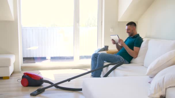 Homme avec tablette PC et aspirateur à la maison — Video