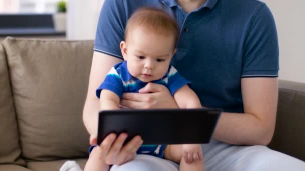 Pojke med far tittar på TabletPC hemma — Stockvideo