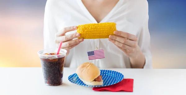 Kvinna äta majs med varmkorv och cola — Stockfoto