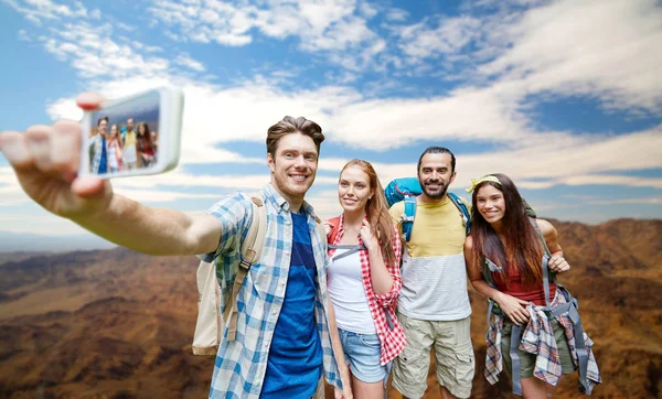 Vrienden met rugzak nemen selfie door smartphone — Stockfoto