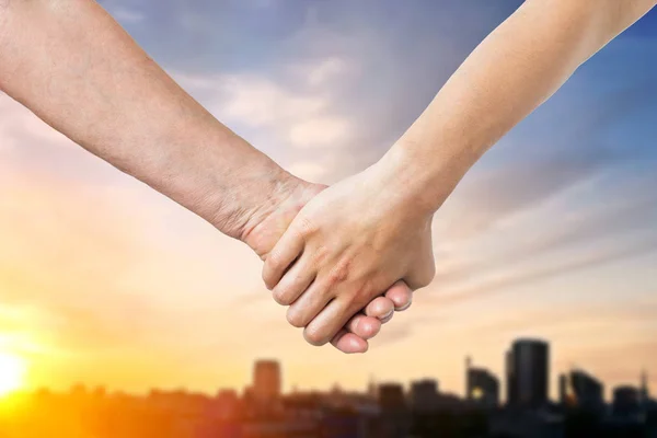 Primer plano de la mujer mayor y joven tomados de la mano — Foto de Stock