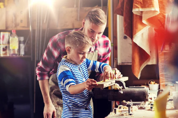 Vater und Sohn mit Lineal messen Holz in Werkstatt — Stockfoto