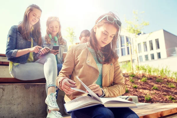 Studentka střední školy čtení knihy venku — Stock fotografie