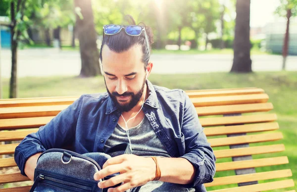 Hombre con mochila y auriculares en la ciudad — Foto de Stock