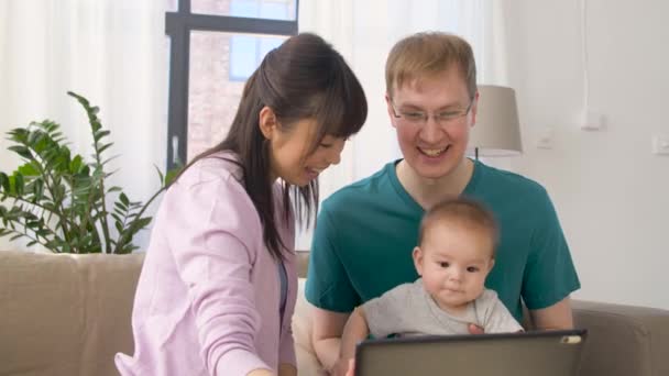 Ευτυχισμένη οικογένεια με το μωρό και το tablet pc στο σπίτι — Αρχείο Βίντεο