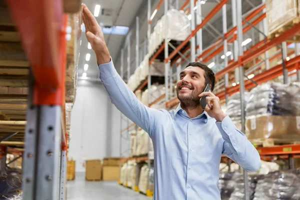 Empresário chamando no smartphone no armazém — Fotografia de Stock