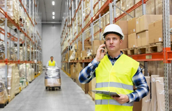 Hombre de negocios llamando en el teléfono inteligente en el almacén — Foto de Stock