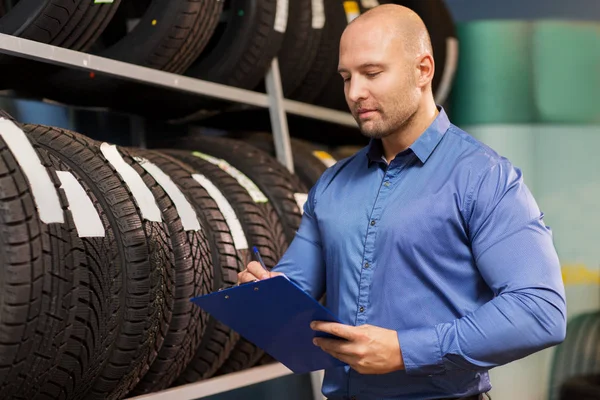 Auto business ιδιοκτήτης και τροχό ελαστικά σε υπηρεσία αυτοκινήτων — Φωτογραφία Αρχείου