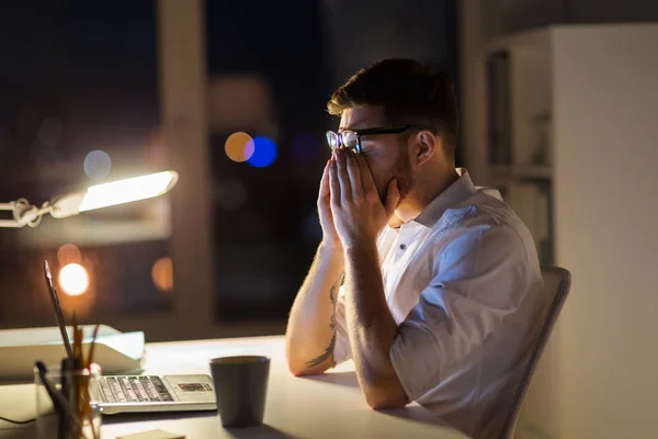 Zmęczony biznesmen z laptopa w biurze noc — Zdjęcie stockowe