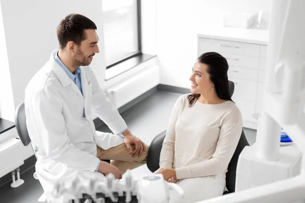 Dentista falando com paciente do sexo feminino na clínica odontológica — Fotografia de Stock