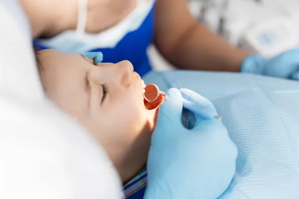 Dentista verificando dentes de criança na clínica odontológica — Fotografia de Stock