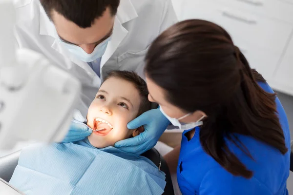 Dentista verificando dentes de criança na clínica odontológica — Fotografia de Stock