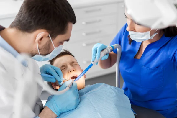 Dentiste traitant les dents d'enfant à la clinique dentaire — Photo