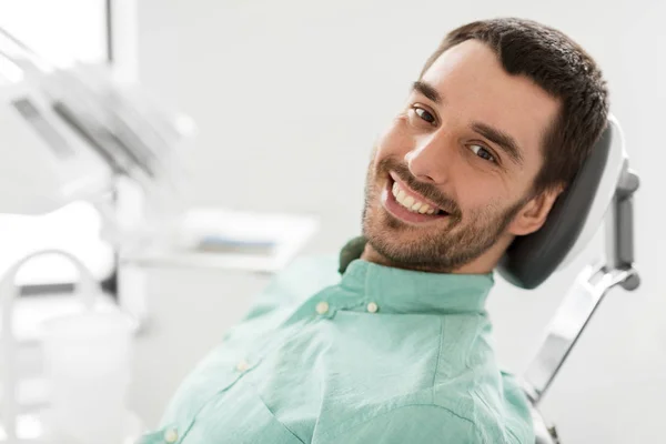 Feliz sorrindo paciente masculino na clínica odontológica — Fotografia de Stock