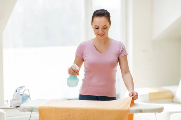 Vrouw of huisvrouw strijken handdoek thuis — Stockfoto