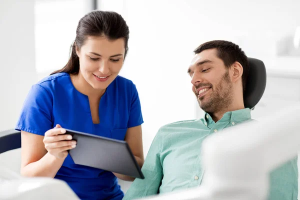 Dentista e paciente com tablet pc na clínica Fotografias De Stock Royalty-Free