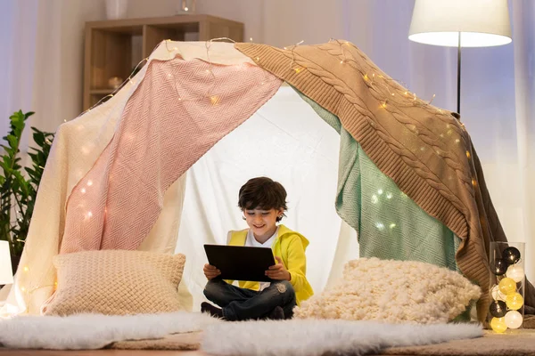 Petit garçon avec tablette pc dans la tente des enfants à la maison — Photo