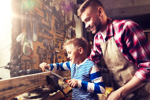Far och son med rasp arbetar på verkstad — Stockfoto