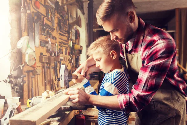 Pai e filho com martelo trabalhando na oficina — Fotografia de Stock