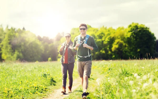 Gelukkige paar met rugzakken buiten wandelen — Stockfoto