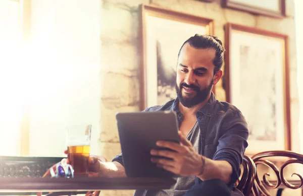 Hombre con la PC tableta beber cerveza en el bar o pub — Foto de Stock
