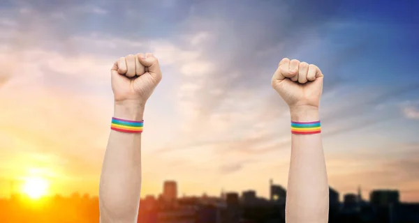 Handen met gay pride regenboog polsbandjes toont vuist — Stockfoto