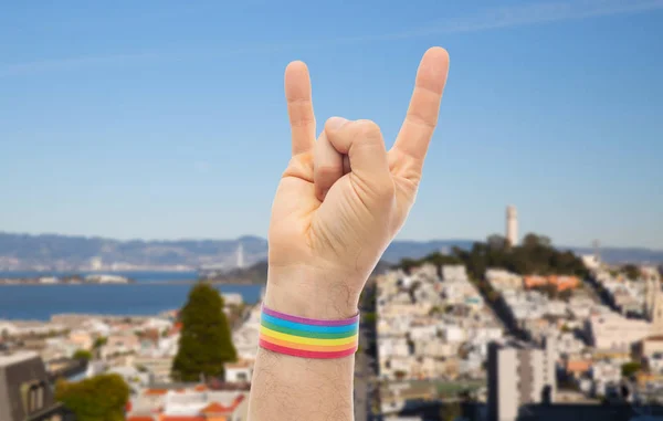手与同性恋骄傲彩虹腕带显示岩石 — 图库照片
