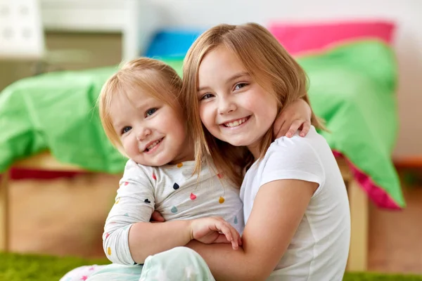 Happy little girls or sisters hugging at home — Stock Photo, Image